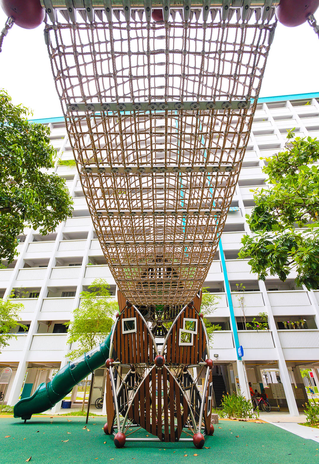Berliner playground's sturdy tunnel bridge challenges balance and coordination, linking to the treehouse playground.