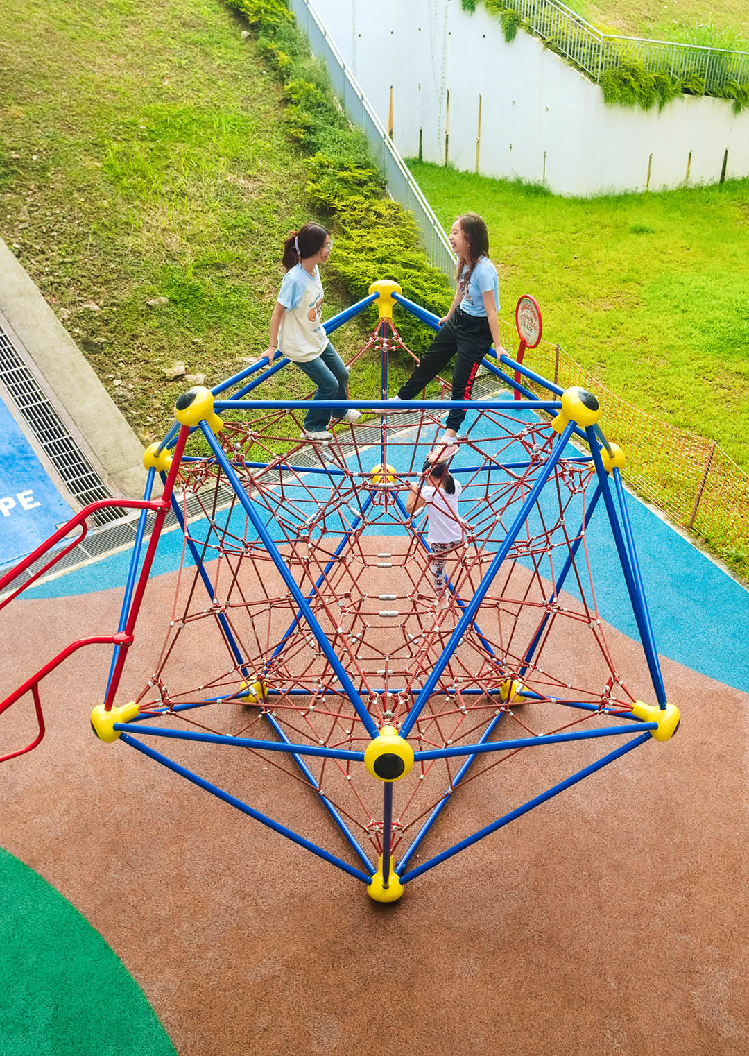 ACS (Junior) playground features Berliner Spaceball and Playworld linked by a swaying rope bridge, fostering safe play.