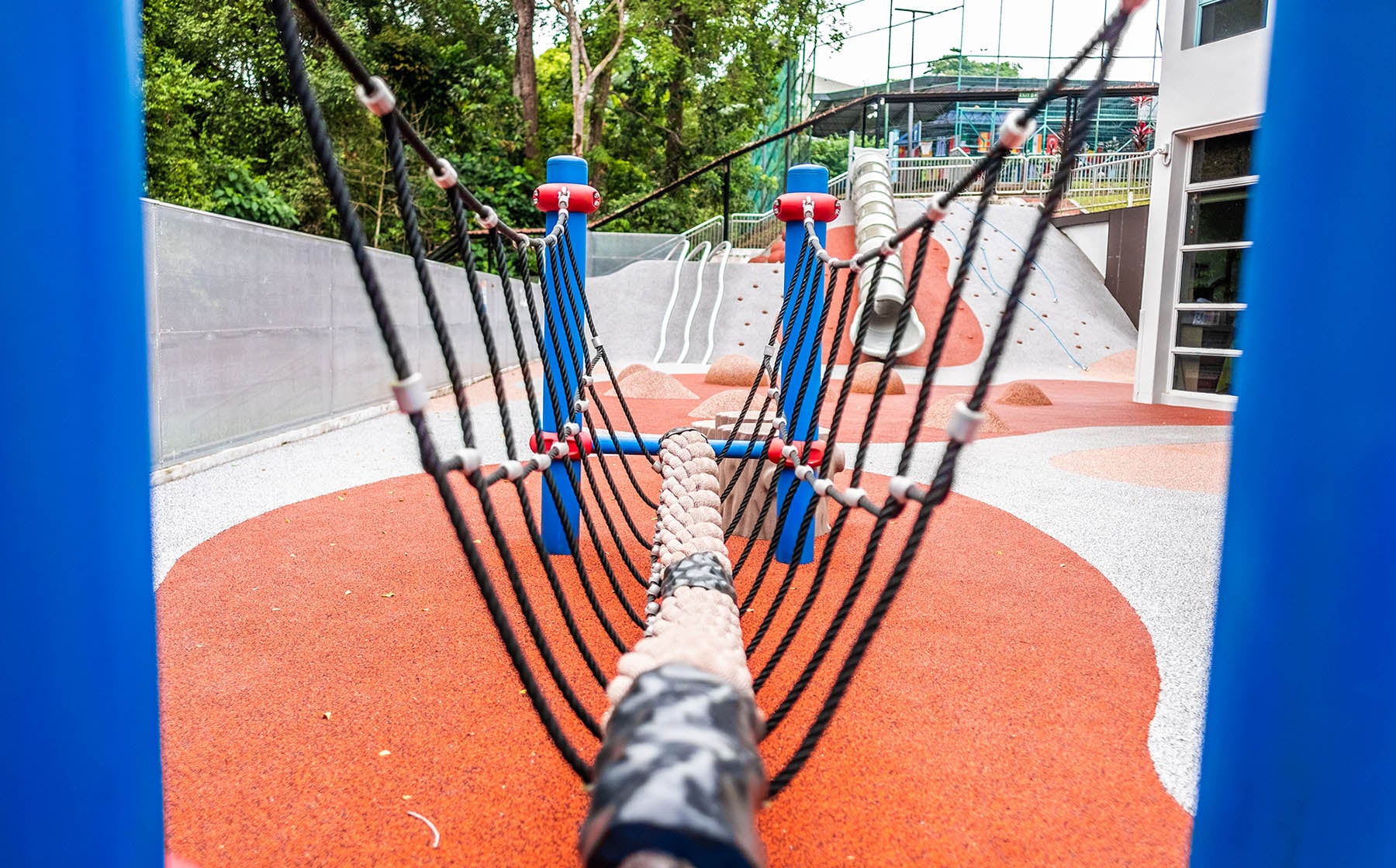 Suspension roped bridge connecting to Berliner Spaceball, enhancing balance and motor skills for children.