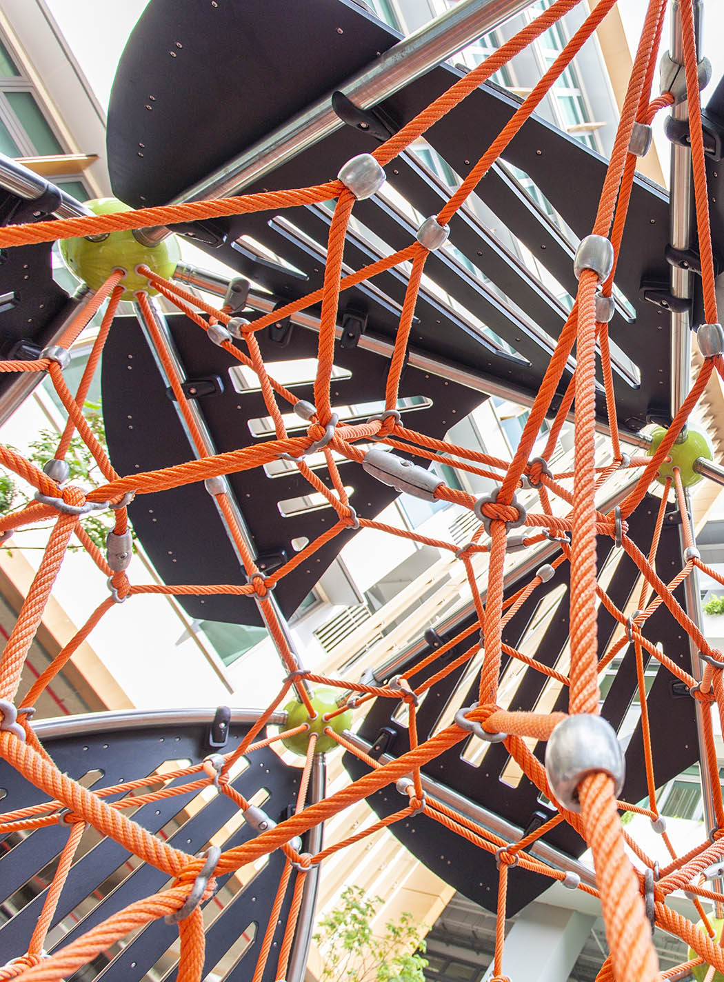 Berliner Greenville featuring rope nets, promoting motor skill development and problem-solving through climbing.