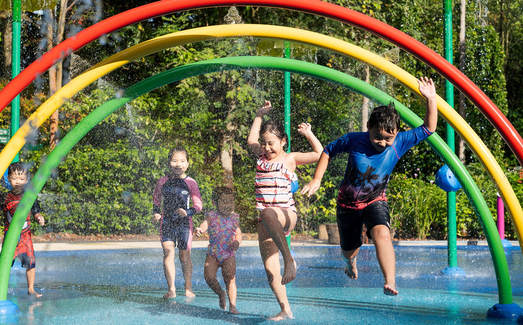 Jacob Ballas Children's Garden with Vortex International rainbow arches pour refreshing water down for kids to enjoy.