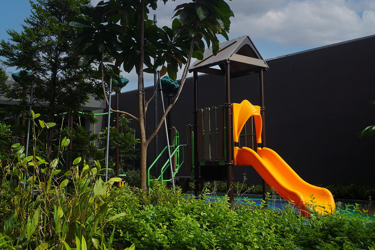 Lentor Modern treehouse-design playground with elevated platform, stair access and a yellow slide for active play.