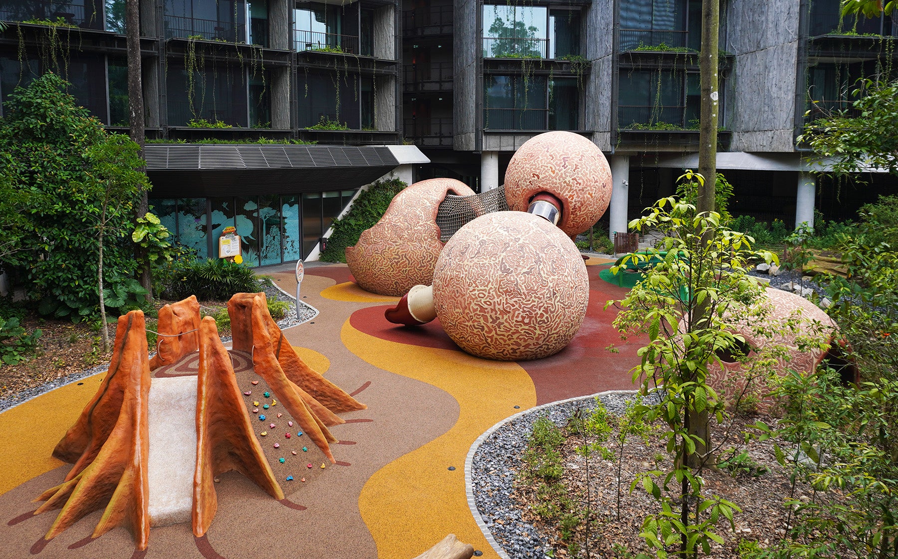 Mandai Rainforest Resort playground equipment shaped like Cannonball fruit and Buttress tree root for nature play.