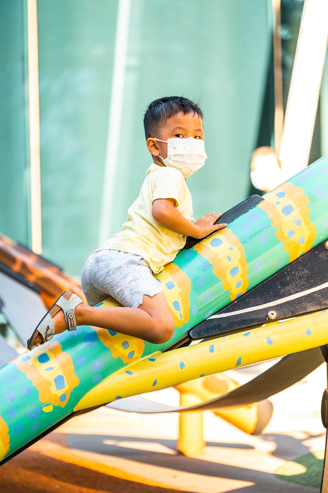 Boy crawling on the Playworld PlayForm 7 playground structure, curiously navigating its interactive design elements.