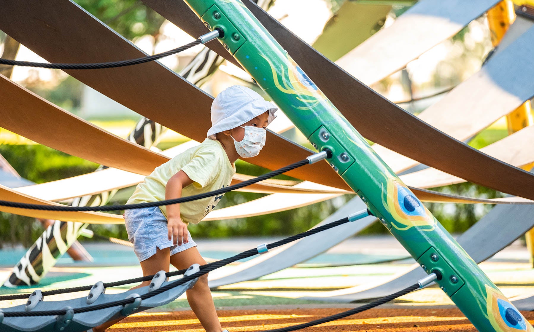 Boy exploring the Playworld PlayForm 7 playground, climbing ropes and panels designed for interactive play.