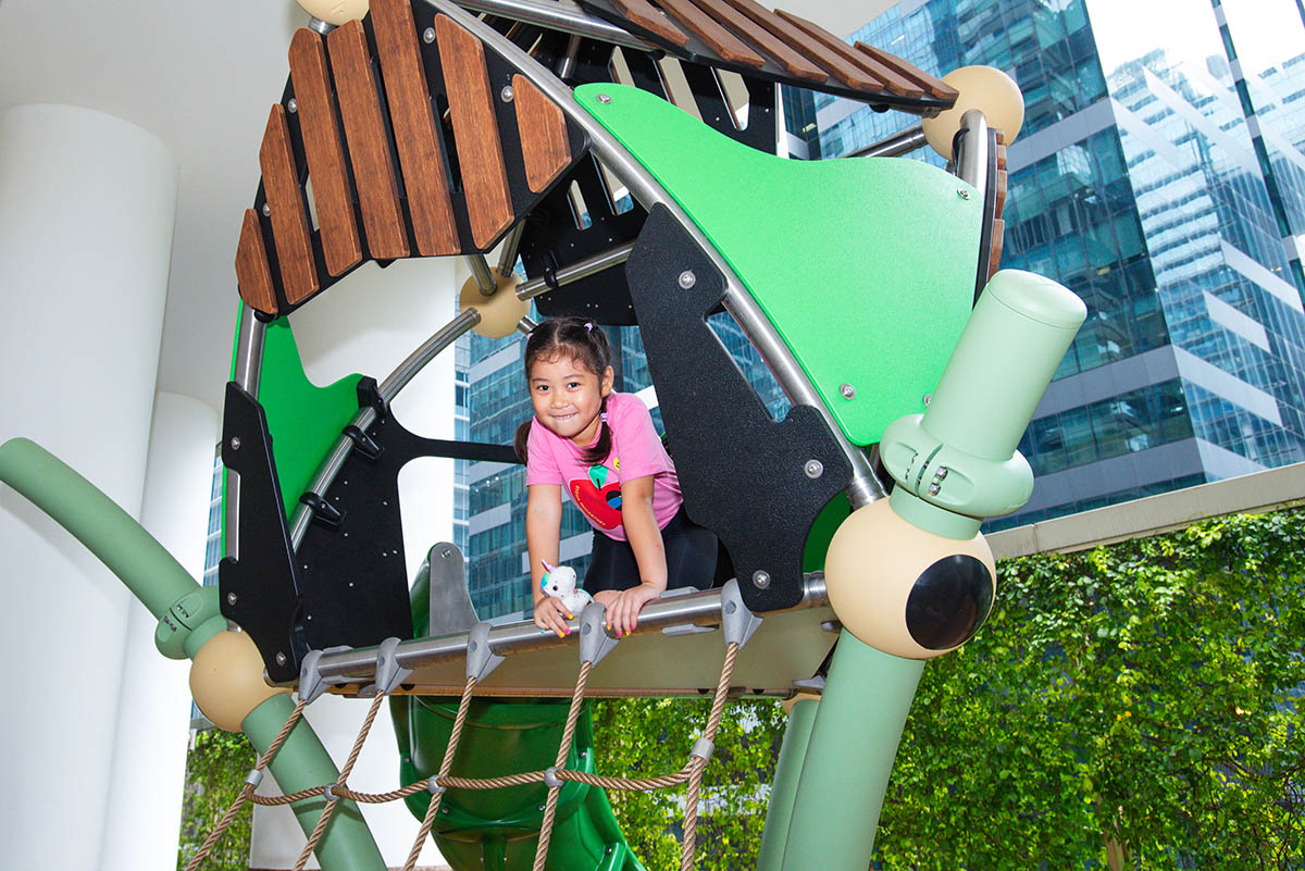 One Shenton playground featuring Berliner Greenville with a rope net and slide for active outdoor play.