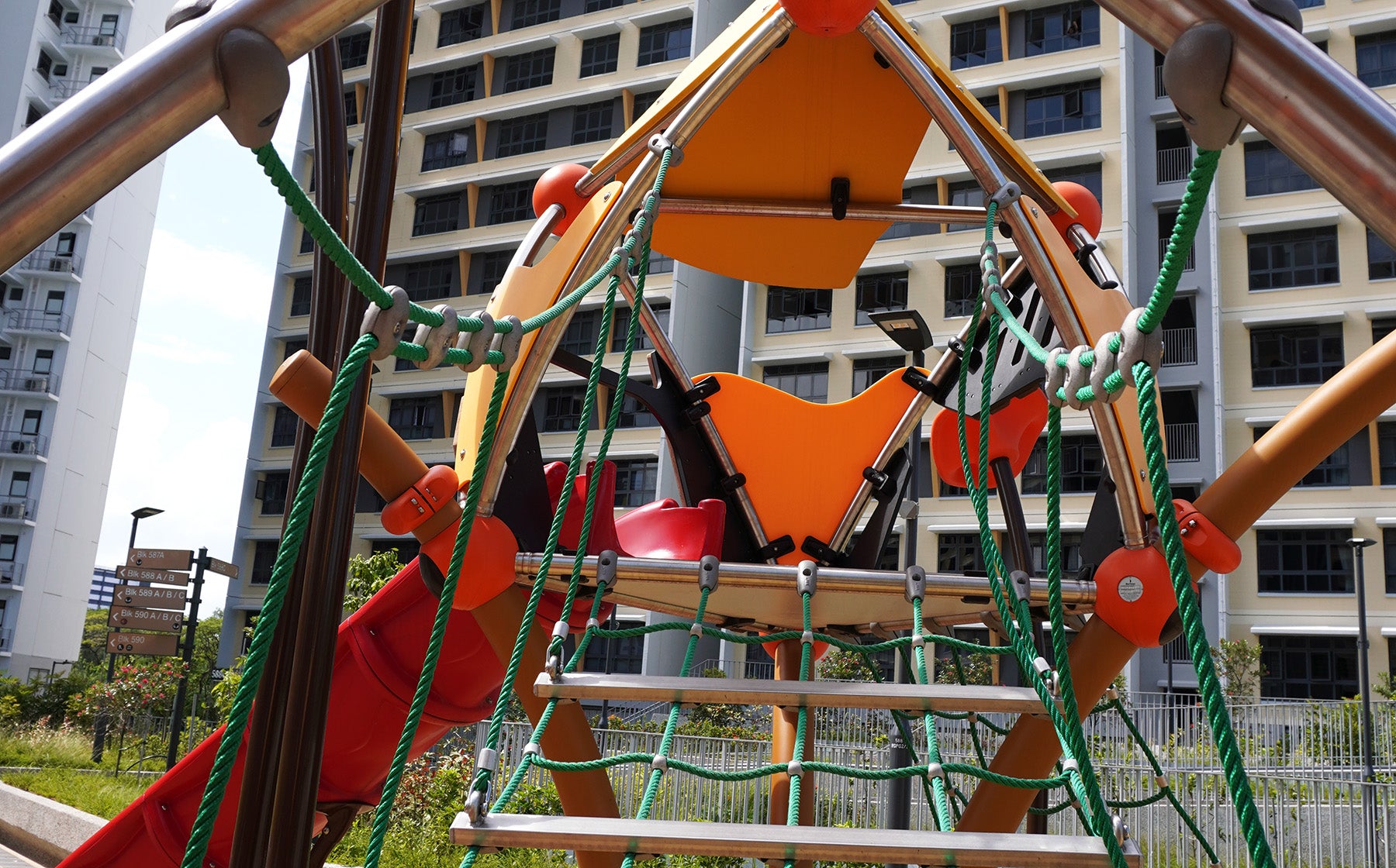 Berliner Greenville play towers are linked by a rope bridge with slides and climbing routes for active play.