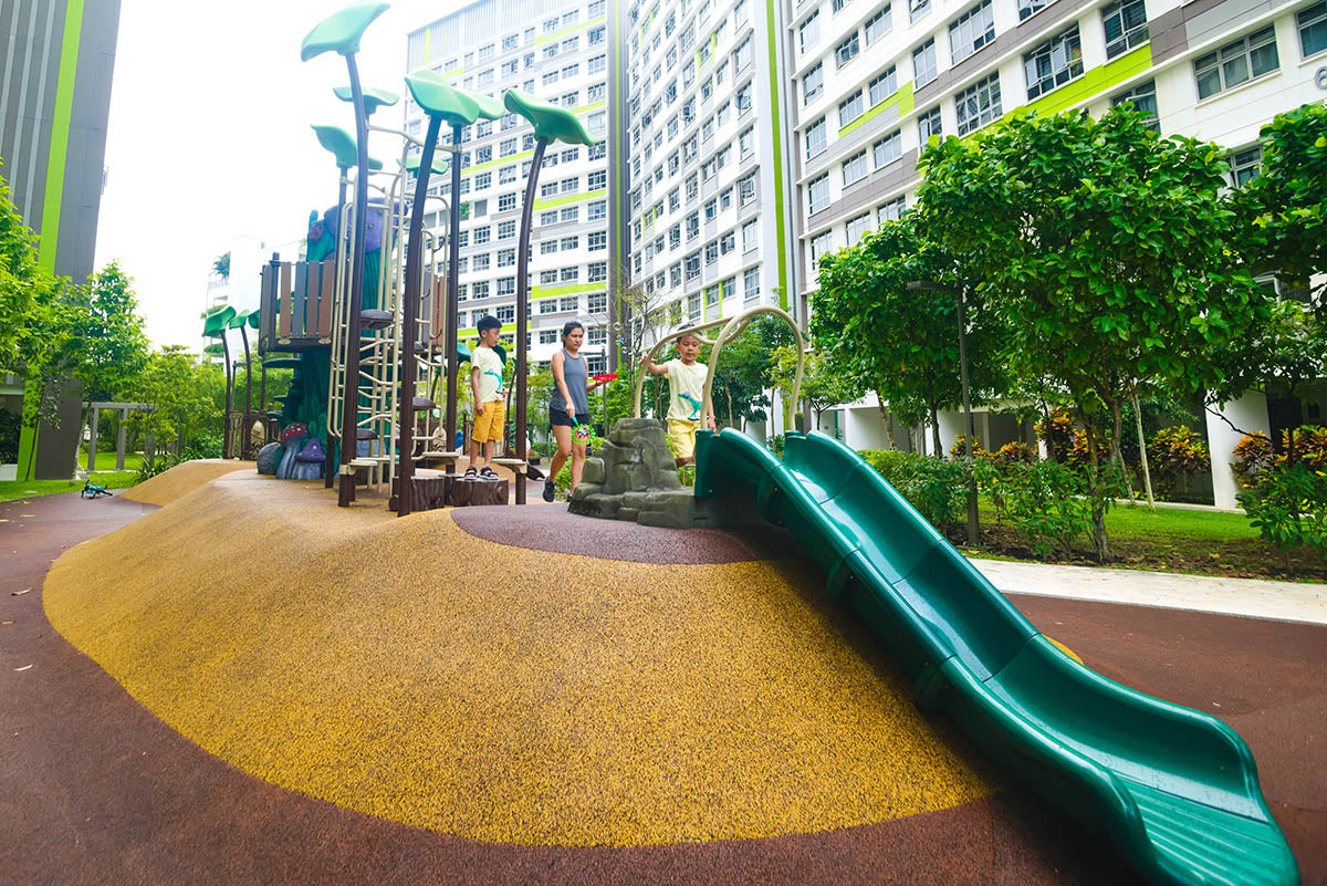 Child preparing to slide down a playground slide, designed with safety features for a fun and secure play experience.