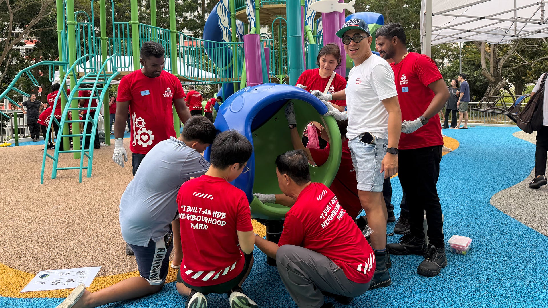 Pasir Ris residents assemble the Cozy Cocoon, securing bolts to ensure a safe and sturdy playground structure.