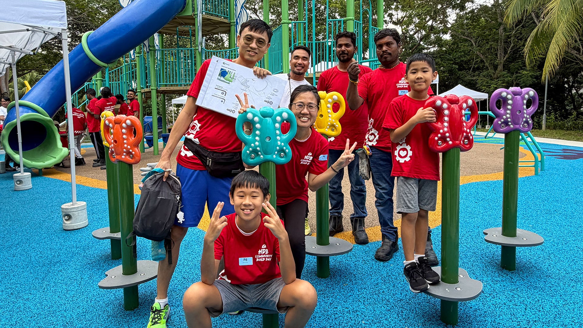 Pasir Ris residents celebrate the completed Butterfly Steppers, smiling proudly at their new playground installation.