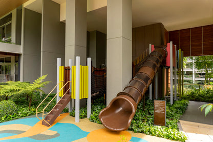 This image features a large brown tubular slide as the centerpiece, downwards slopping from a wooden play structure. 