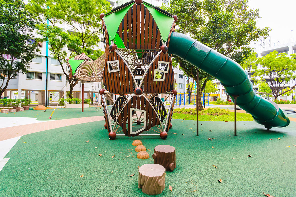 A playground with various play structures, including swings, slides, and climbing areas, providing a fun and safe environment for children to explore and enjoy.