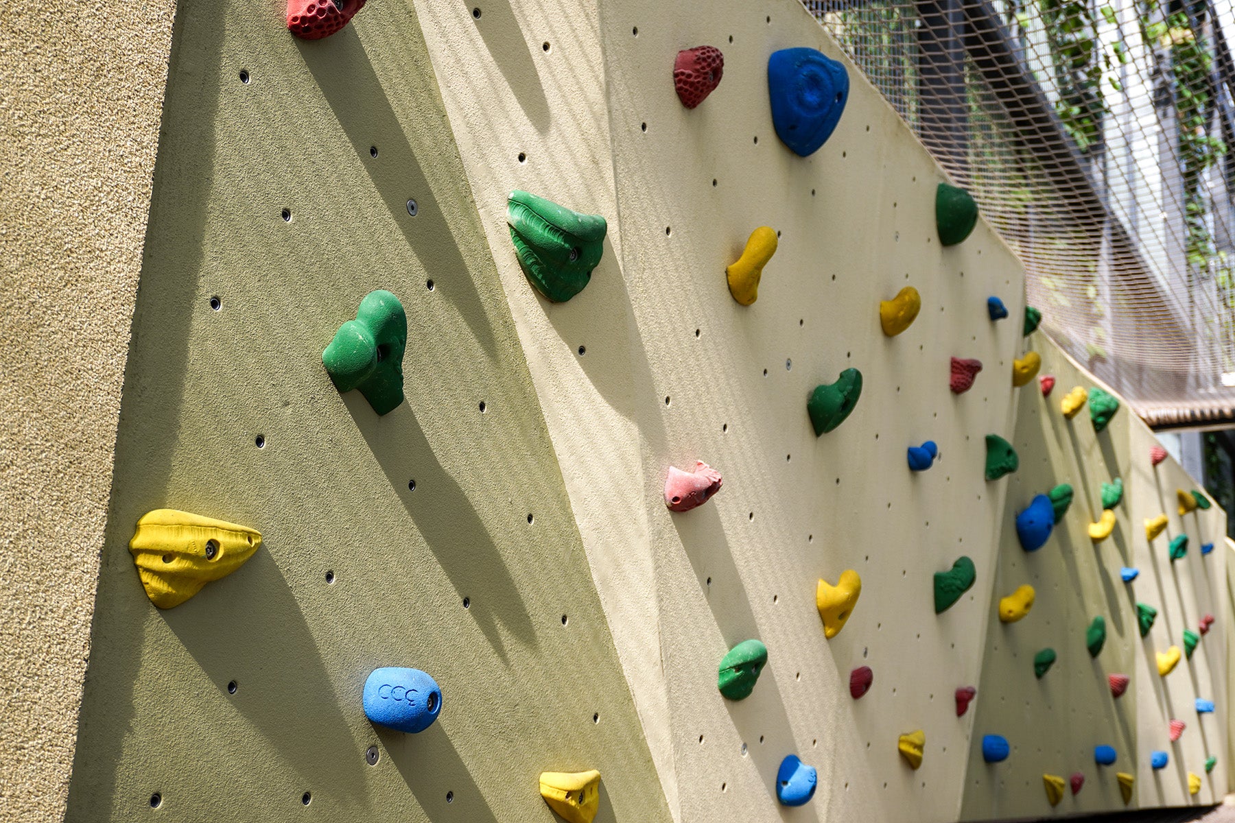 A rock climbing structure with colourful handholds and footholds, designed for climbers to challenge themselves and improve strength.