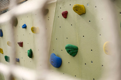 A rock climbing structure, showing various handholds and footholds for climbers to grip and climb.



