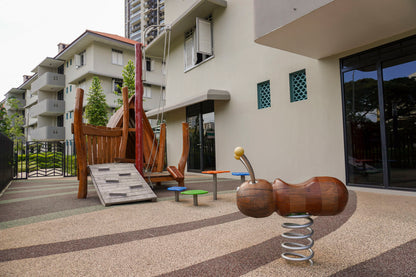 A playground with a bee spring rocker and a small obstacle structure, designed for little children to play and explore.