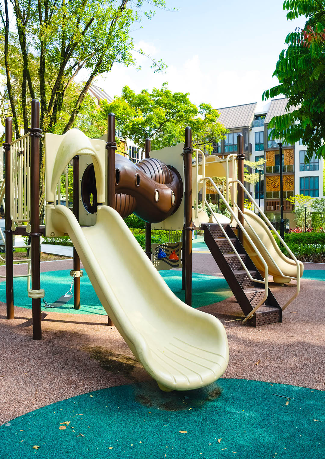 A vibrant playground featuring slides, climbing structures, and open spaces, designed for children to explore and play.