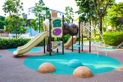 A beautifully designed playground with cute play structures, swings, and slides, offering a space for children to explore.