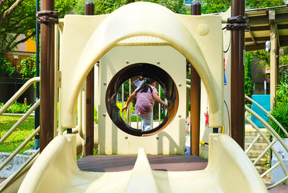 The girl is joyfully exploring the fun and excitement of the playground.