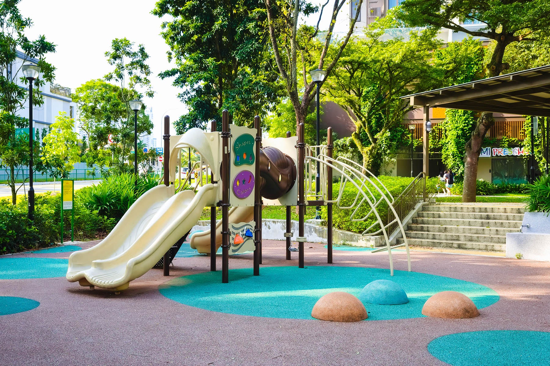 A vibrant playground with slides, climbing structures, and soft ground, designed for children to play and explore safely.