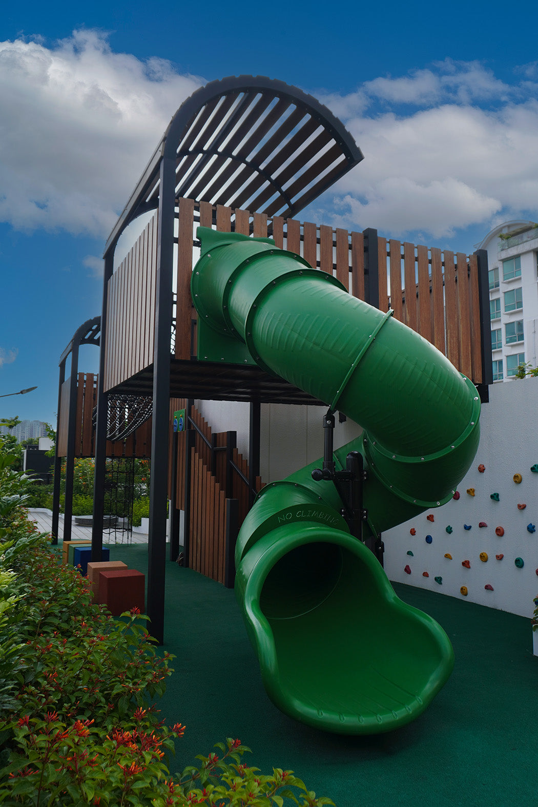 Jervois Mansion playground features a green spiral slide that delivers exciting play from an elevated platform.