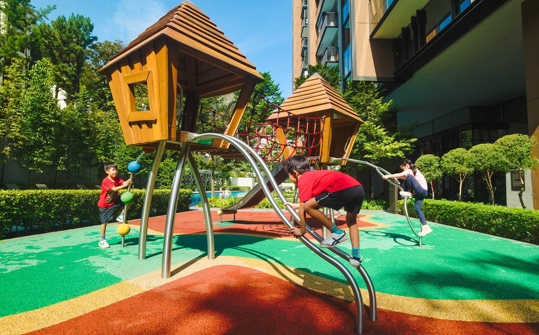 A boy crawling up curved metal poles to reach the top of the playground, engaging in an adventurous climb.