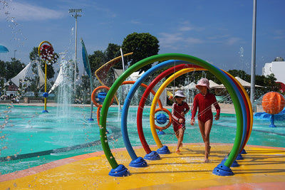 Vibrant rainbow Jurong East Swimming Complex waterplay featuring interactive spray tunnels and kid-friendly splash pads.