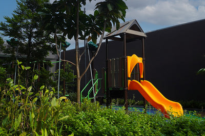 Lentor Modern treehouse-design playground with elevated platform, stair access and a yellow slide for active play.