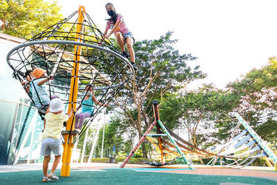 Children enjoying the Playworld diamond cone spinner, holding onto the structure while spinning.