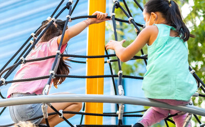 Children enjoying the Playworld Diamond Cone Spinner playground, holding on while spinning with fun and excitement.