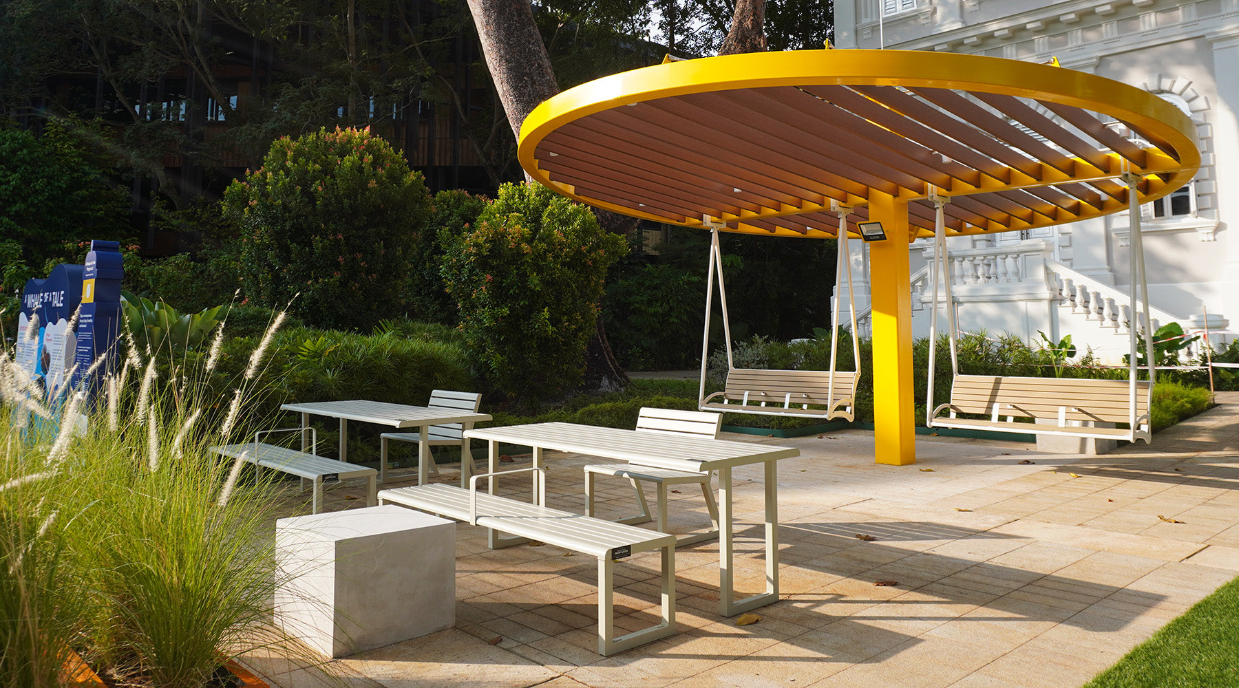 Outerspace outdoor picnic area with tables, chairs in a garden setting.
