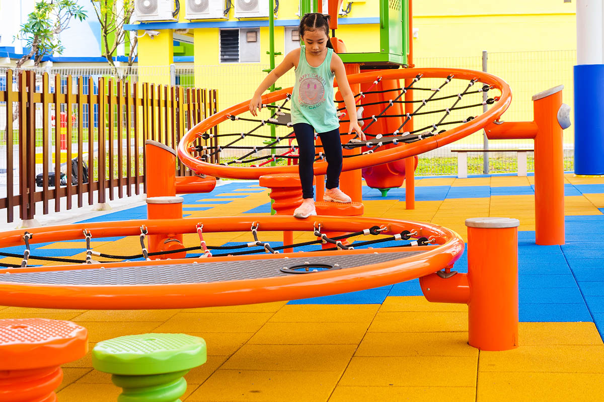 Shaded playground with Playworld infiNET, providing barrier-free platform nets and versatile climbing challenges.