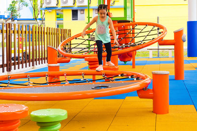 Shaded playground with Playworld infiNET, providing barrier-free platform nets and versatile climbing challenges.