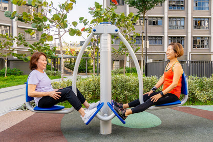 Two elderly people happily exercise on the leg press machine, working out together to strengthen upper leg muscle in a fitness corner. 