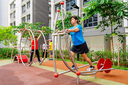 A woman exercises on a cross trainer, focusing on her workout in a fitness corner.