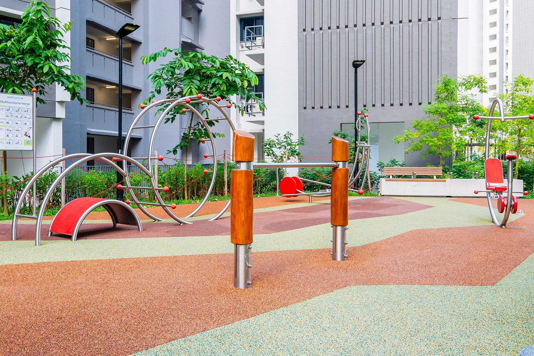 Outdoor fitness corner with soft, cushioned ground, featuring various exercise equipment in a safe and inviting environment.