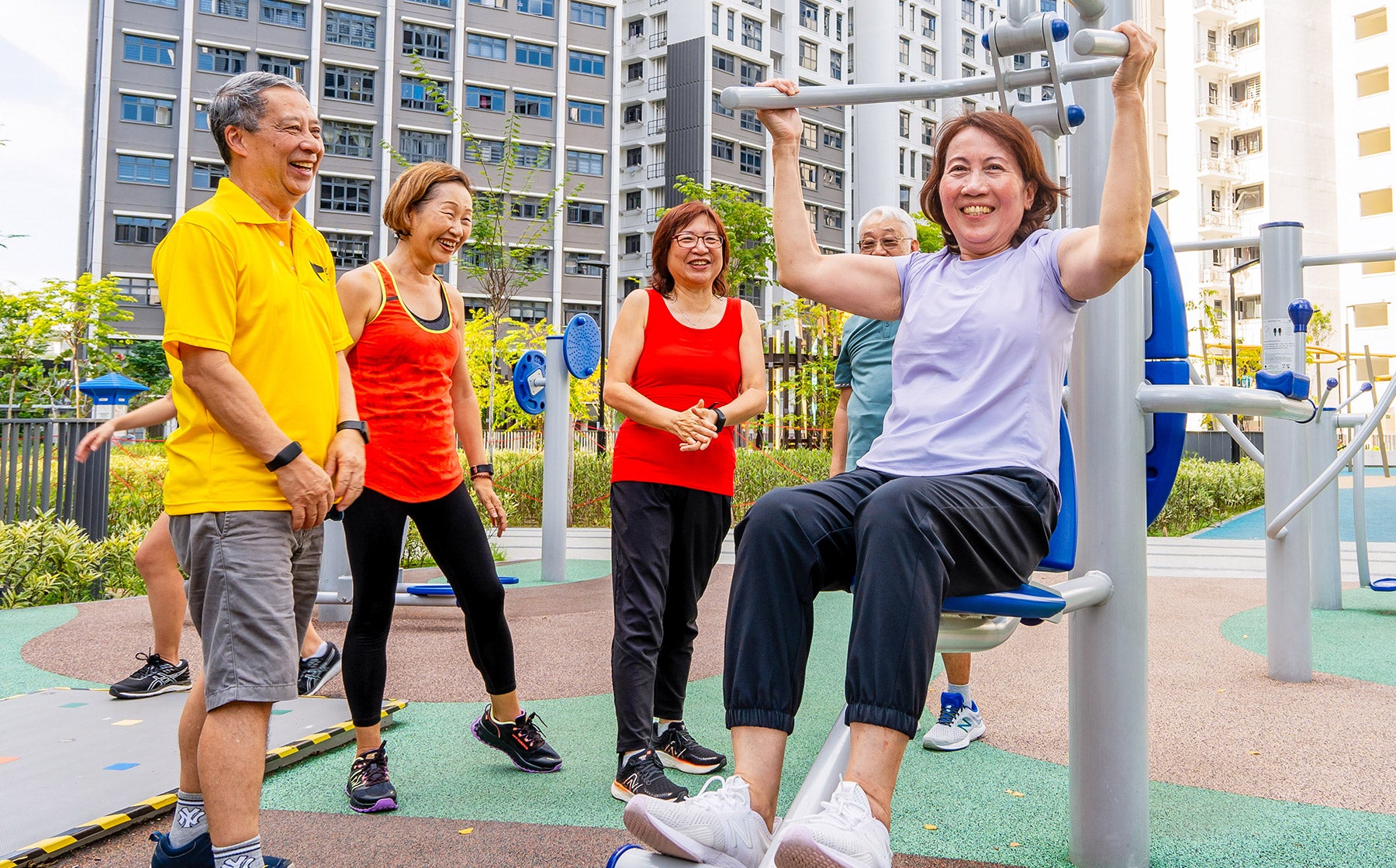 Fitness corner with elderly cheering and encouraging for one another while using the equipment to improve arm strength , promoting community bonding.