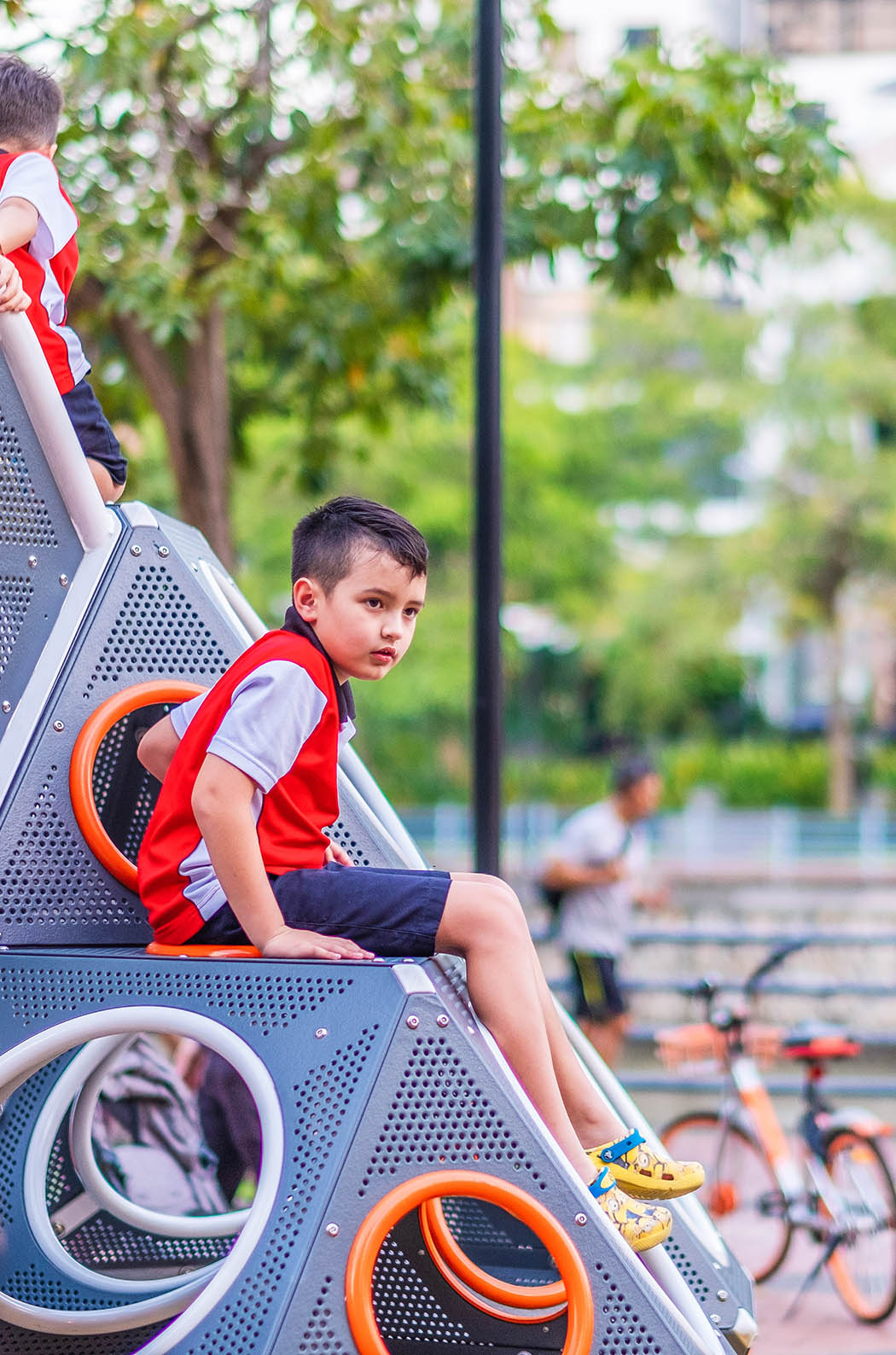 Boy looking focused after climbing up the Playworld PlayCube structure.