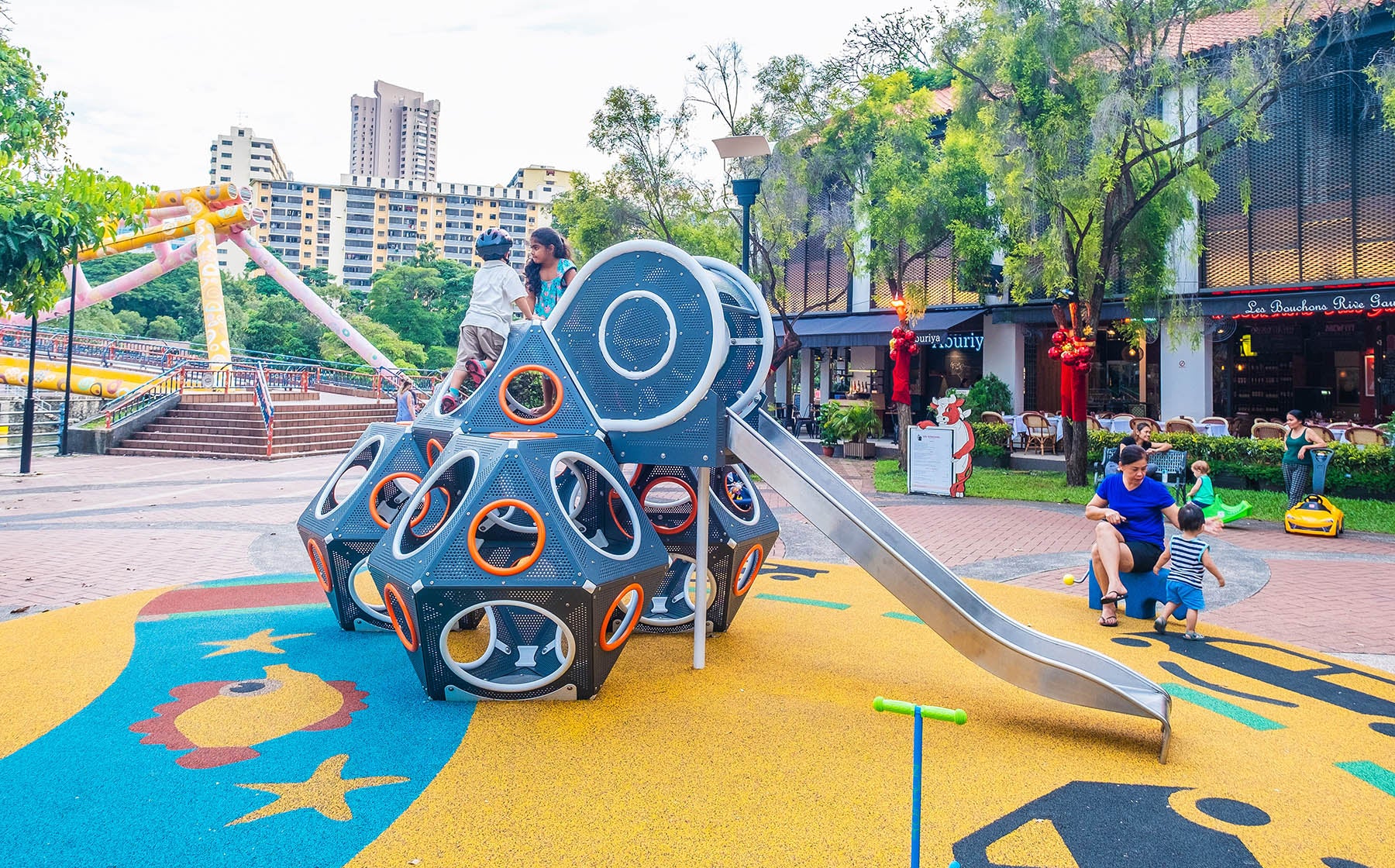 The children are climbing up the complex Playworld PlayCube structure, preparing to slide down the slide.