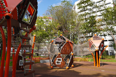 Berliner Greenville Trii treehouses linked by rope tunnels create a connected elevated play adventure.